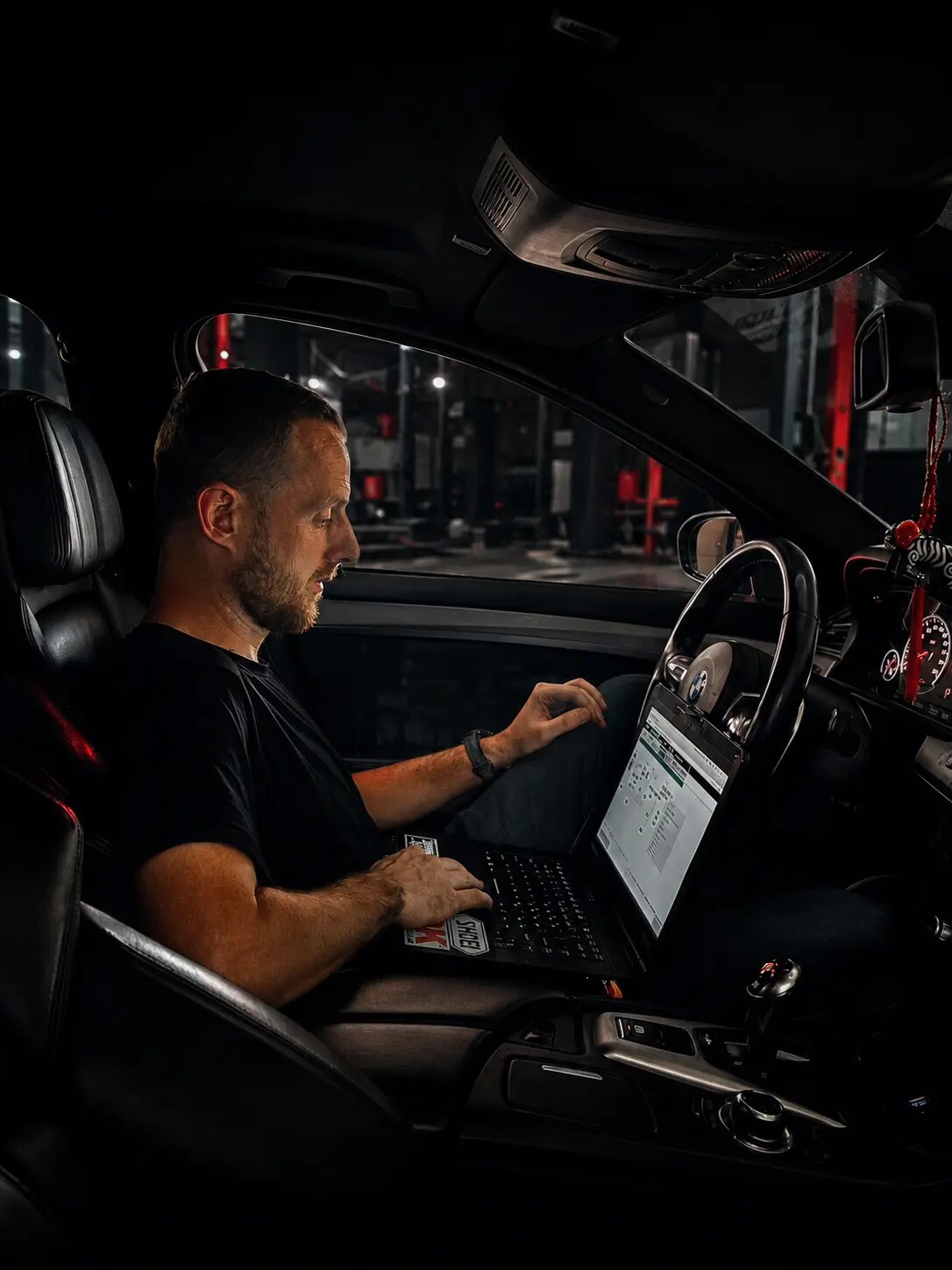 Brandon performing BMW diagnostic work inside a vehicle